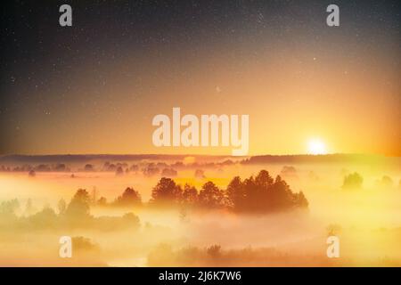 Stelle stupende cielo stellato sopra Misty nebbia Paesaggio Scenico Vista del cielo del mattino con il sole in ascesa sopra la foresta. Notte cielo stellato cielo stellato incandescente Stelle Foto Stock