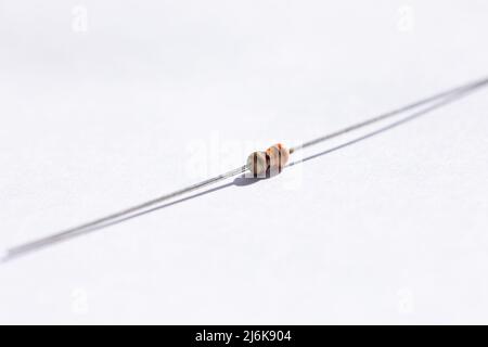 Ritratto in primo piano di un resistore da 330 ohm con una tolleranza del 5%. Le parti elettriche sono isolate su sfondo bianco ed è pronte per l'uso in un impianto elettrico Foto Stock