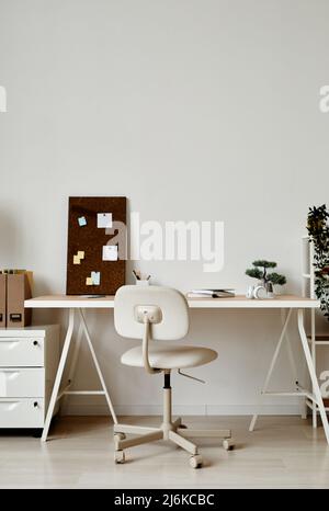 Sfondo verticale di un semplice ufficio domestico in bianco con albero bonsai sulla scrivania Foto Stock