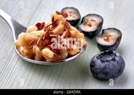 Porridge di avena a grani interi con mirtilli e semi di lino Foto Stock
