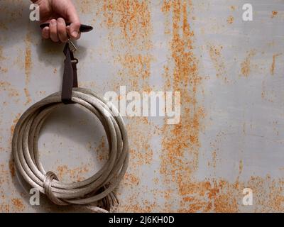 La mano pesa un mazzo di fili metallici, spazio copia. Prendendo rame o alluminio come rottami di metalli non ferrosi Foto Stock