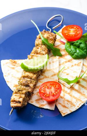 spiedino di carne alle erbe con pita pane, pomodori e lime Foto Stock