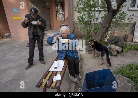 Kharkiv, Ucraina. 02nd maggio 2022. Oleg Petyushenko, 46, a sinistra, e Lyudmyla Mikhailivna Kirichenko, 75, a destra, mangiare zuppa come Sasha Zolotov, 55, lega il suo cane di fronte al loro appartamento vicino al confine russo a Kharkiv, Ucraina, Lunedi, 2 maggio 2022. I funzionari israeliani più importanti lunedì hanno condannato le osservazioni del capo diplomatico russo che sostenevano che il leader nazista Adolf Hitler era ebreo e implicavano che i prigionieri ebrei durante la seconda guerra mondiale fossero responsabili della propria morte nell'Olocausto. Foto di Ken Cedeno/UPI Credit: UPI/Alamy Live News Foto Stock