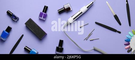 Set di forniture per manicure su sfondo lilla, vista dall'alto Foto Stock