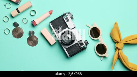 Fotocamera vintage, gioielli e accessori eleganti su sfondo blu chiaro, vista dall'alto Foto Stock