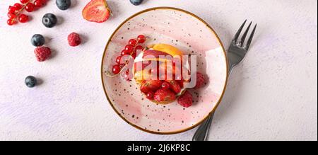 Piatto con gustosa crostata di frutti di bosco su sfondo chiaro, vista dall'alto Foto Stock