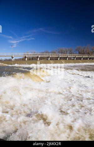 Ponte pedonale e diga di controllo del flusso d'acqua sul fiume Mille-Iles con un alto livello d'acqua in primavera, Terrebonne, Lanaudiere, Quebec, Canada Foto Stock