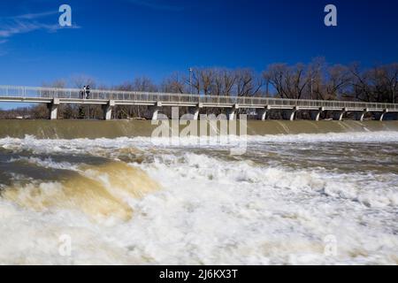 Ponte pedonale e diga di controllo del flusso d'acqua sul fiume Mille-Iles con un alto livello d'acqua in primavera, Terrebonne, Lanaudiere, Quebec, Canada Foto Stock