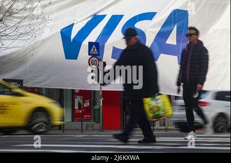 Bucarest, Romania - 03 gennaio 2022: Una grande pubblicità VISA (fuoco selettivo - intenzionaly motion blur) su un enorme banner è stato sollevato su un bui Foto Stock