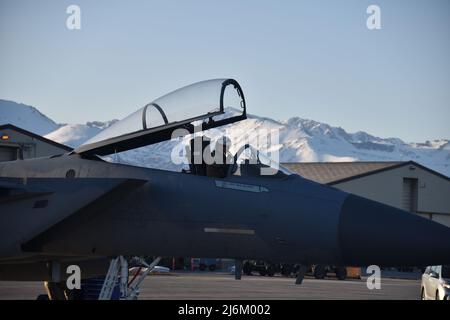 Ben Hale, un pilota assegnato al 194th Fighter Squadron, 144th Fighter Wing, si prepara a lanciare una F-15C Eagle sulla linea del flightline della Joint base Elmendorf-Richardson, Alaska, 20 aprile 2022, mentre conduce un dissimile addestramento di combattimento aereo con i F-22 Raptors della 3rd Wing. La formazione di JBER si è concentrata sull'integrazione dei combattenti tra le aquile F-15 di quarta generazione e i Raptor F-22 di quinta generazione e sulla loro capacità di interagire senza problemi. (STATI UNITI Air National Guard foto di Capt. Jason Sanchez) Foto Stock