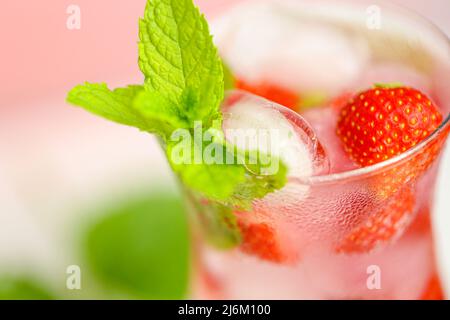 Drink alla fragola. Drink estivi. Cocktail rinfrescante. Acqua in bicchiere con ghiaccio e fragole. Acqua minerale con ghiaccio e fragole Foto Stock