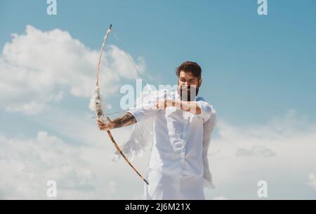 Sorpreso Cupido con ali puntate con arco e freccia su sfondo cielo. Divertente giorno valentines concetto. Foto Stock