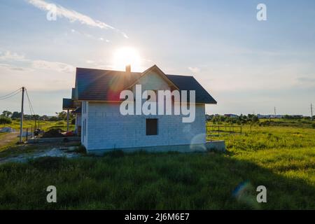 Vista aerea di casa incompiuta con pareti in calcestruzzo leggero aerato e telaio del tetto in legno rivestito con piastrelle metalliche in costruzione Foto Stock