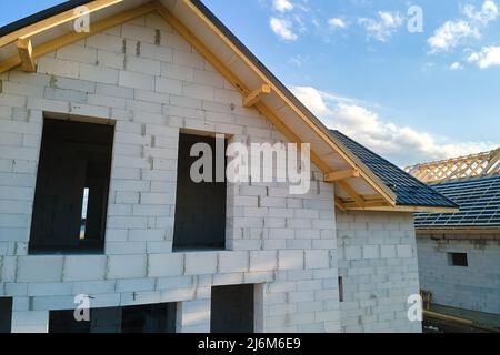 Vista aerea di casa incompiuta con pareti in calcestruzzo leggero aerato e telaio del tetto in legno rivestito con piastrelle metalliche in costruzione Foto Stock