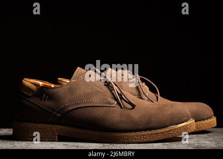 Vista laterale di scarpe marroni con lacci su sfondo nero. Foto Stock