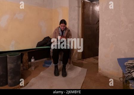 KIEV, UCRAINA 26 FEBBRAIO. Maria Pysarenko, siede all'interno di un riparo sotto la sua casa situata vicino all'edificio dell'ufficio presidenziale mentre le sirene di incursioni aeree si dischiudono il 25 febbraio 2022 a Kiev, Ucraina. La Russia ha iniziato un'invasione militare dell'Ucraina dopo che il parlamento russo ha approvato trattati con due regioni separatiste nell'Ucraina orientale. E' il più grande conflitto militare in Europa dalla seconda guerra mondiale Foto Stock