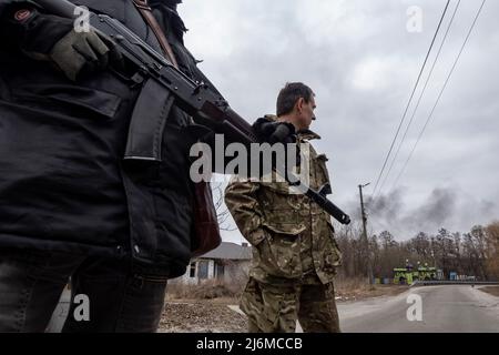 HORENKA, UCRAINA 07 marzo. Un membro delle forze di difesa territoriale osserva il fumo che sale dopo essere stato gridato nei pressi del villaggio frontline di Horenka, a nord della capitale di Kyiv, mentre l'invasione russa dell'Ucraina continua il 07 marzo 2022 a Horenka, Ucraina. La Russia ha iniziato un'invasione militare dell'Ucraina dopo che il parlamento russo ha approvato i trattati con due regioni in distacco nell'Ucraina orientale. È il più grande conflitto militare in Europa dalla seconda guerra mondiale Foto Stock