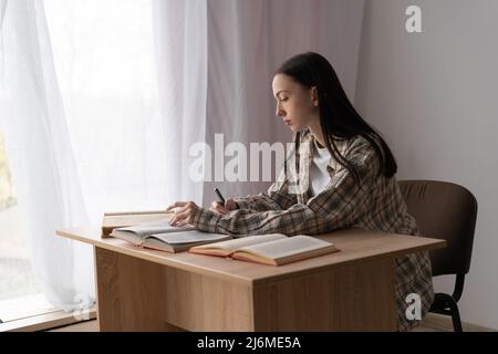 istruzione e concetto di università, giovane studente asiatico scrittura compiti mentre studiano a casa a distanza, l'apprendimento a distanza, triste studente di scuola superiore fare Foto Stock