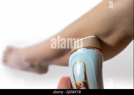 Gambe più belle grazie alla moderna rimozione dei peli con un dispositivo per la rimozione dei peli Foto Stock