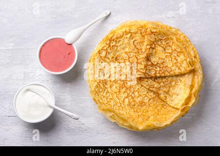Deliziosa dieta a basso contenuto di Carb fatta in casa Keto Pancakes senza farina e noci con marmellata di fragole e panna acida su sfondo grigio testurizzato, vista dall'alto. Ketoge Foto Stock