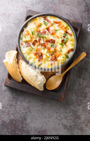 Zuppa di patate polacca con pancetta tradizionale Kartoflanka closeup nel recipiente sul vassoio di legno vista verticale dall'alto Foto Stock