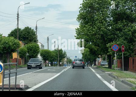 Varsavia, Polonia - 11 giugno 2021: Auto sulla strada e alberi verdi sulla strada. Traffico auto in un giorno d'estate. Foto Stock