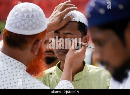 Guwahati, Assam, India. 03rd maggio 2022. Un uomo musulmano che applica Surma agli occhi prima di offrire la preghiera a un Eidgah per iniziare il festival Eid al-Fitr, che segna la fine del loro santo mese di digiuno del Ramadan, a Guwahati, Assam, India il 03 maggio 2022. Credit: David Talukdar/Alamy Live News Foto Stock