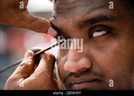 Guwahati, Assam, India. 03rd maggio 2022. Un uomo musulmano che applica Surma agli occhi prima di offrire la preghiera a un Eidgah per iniziare il festival Eid al-Fitr, che segna la fine del loro santo mese di digiuno del Ramadan, a Guwahati, Assam, India il 03 maggio 2022. Credit: David Talukdar/Alamy Live News Foto Stock