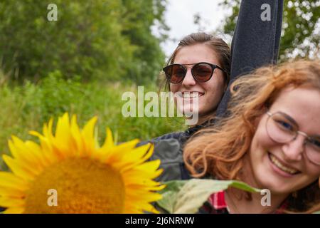 Ragazze che fanno foto di gruppo tenendo girasole Foto Stock