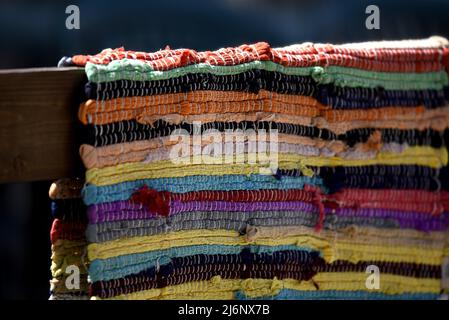 Tradizionale tappeto Kourelou colorato intrecciato a mano appeso su una ringhiera di legno recinzione a Platanos, Arcadia Peloponneso, Grecia. Foto Stock