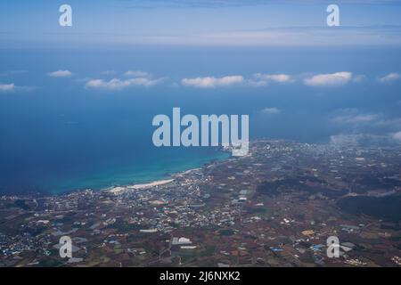 Vista aerea dell'isola di Jeju e del mare dall'aeroplano Foto Stock