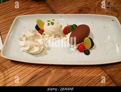 Dessert estivo al sorbetto con gelato al sorbetto al cocco, gelato al sorbetto all'ananas e gelato al sorbetto al lime servito su un tavolo del ristorante. Foto Stock