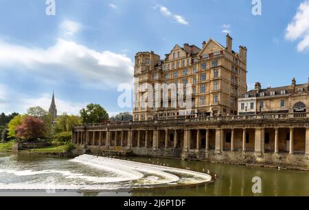 L'ex Empire Hotel e Saint Johns Church sul fiume Avon e Pulteney Weir, Bath, Somerset, Inghilterra, Gran Bretagna, Regno Unito. Foto Stock