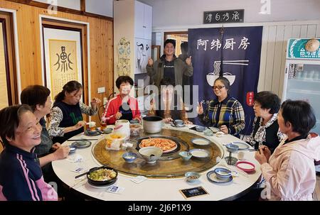 XIAMEN, 3 maggio 2022 (Xinhua) -- Chen Wayne (indietro) pone per una foto con i clienti al suo ristorante di famiglia a Xiamen, provincia del Fujian della Cina sud-orientale, 2 maggio 2022. Wang Shengfen, 37, e Chen Wayne, 24, da Kaohsiung e Taichung della Cina sud-orientale di Taiwan, entrambi si impegnano in affari di ristorazione a Xiamen. Wang gestisce una 'mensa tarda notte' e Chen apre un ristorante per famiglie con suo padre. Nel 2016, Wang Shengfen e suo padre sono venuti in terraferma per cercare opportunità di business. Presto aprì un ristorante con gli amici nel quartiere Jimei di Xiamen. Nel 2022, lui Foto Stock