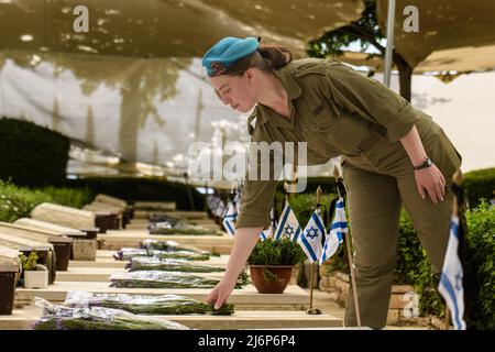 (220503) -- KIRYAT SHEMONA, 3 maggio 2022 (Xinhua) -- un soldato israeliano commemora i soldati caduti in un cimitero militare nella città israeliana settentrionale di Kiryat Shemona il 3 maggio 2022. Israele, dal martedì sera al mercoledì sera, segna il Memorial Day (Yom HaZikaron) per commemorare i soldati caduti e i civili uccisi nelle ostilità dal 1860. (Ayal Margolin/JINI via Xinhua) Foto Stock