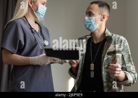 operatore medico con ufficiale militare paziente in ospedale Foto Stock