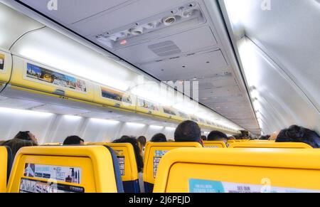 Interno di un aereo passeggeri Ryanair pieno di persone Foto Stock