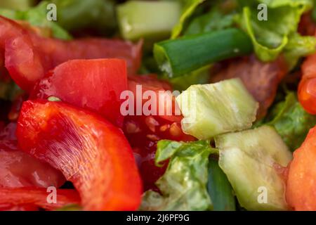 Primo piano di insalata assortita succosa composta da foglie di insalata verde, pomodoro, paprika e cetriolo Foto Stock