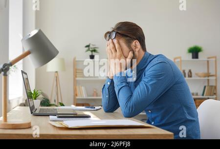 Il giovane uomo d'affari riceve una lettera con cattive notizie e viene sottolineato sui suoi problemi Foto Stock