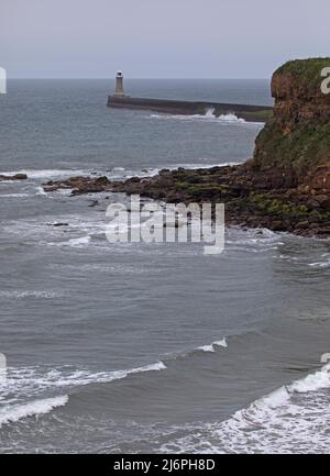 Tynemouth, North Shields, Inghilterra. £13 maggio 2022. Nuvoloso e fresco al mare nord-est per le poche persone sulla spiaggia, temperatura pomeridiana di 11 gradi prima della pioggia impostata in tarda notte. Nella foto: Piccole onde che entrano in riva con il faro del molo di Tynemouh sullo sfondo. Credit: Archwhite/alamy live news. Foto Stock