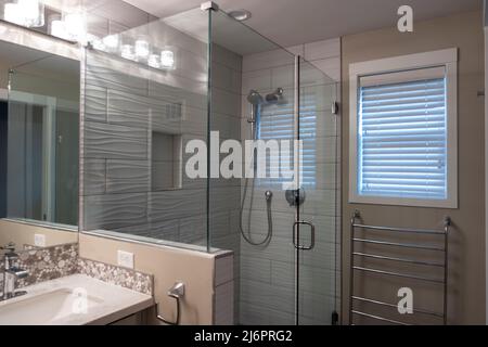 Vista ad angolo di una doccia in vetro con soffione estraibile Foto Stock