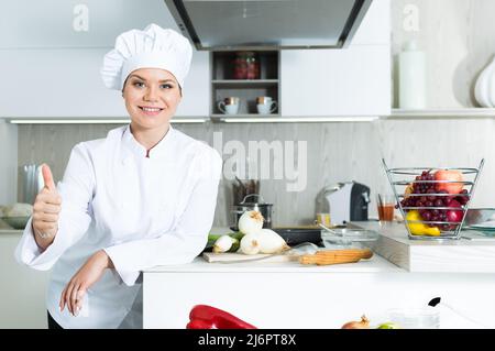 Ritratto della donna proffesional che sta posando in cucina Foto Stock