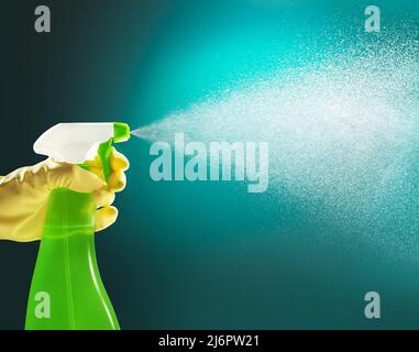 mano che tiene un flacone di detergente per pompe spruzzando liquido Foto Stock