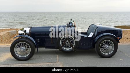 Classica Teal Bugatti auto da corsa parcheggiata sul lungomare mare in background. Foto Stock