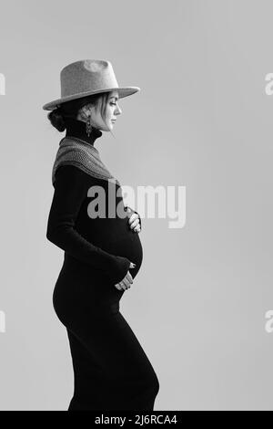 bella donna incinta in vestito che tiene il suo ventre Foto Stock