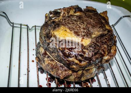 Cotto due costolette di manzo arrosto su rack in una padella di tostatura Foto Stock