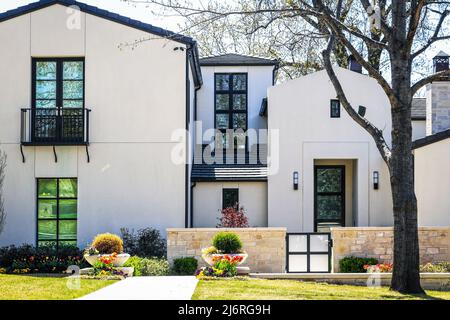 Elegante moderna casa in stucco bianco in primavera con bel paesaggio un albero appena in erba. Foto Stock