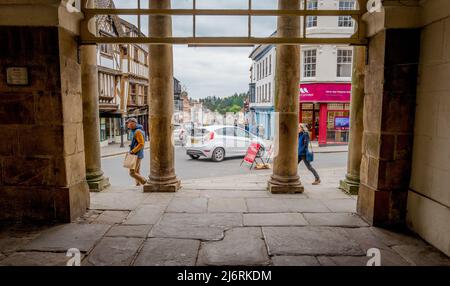 Le colonne di pietra del municipio e museo di Ludlow che guardano lungo la strada larga, Ludlow, Shropshire, Inghilterra. Foto Stock