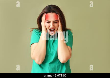 Giovane donna stressata che soffre di mal di testa su sfondo colorato Foto Stock