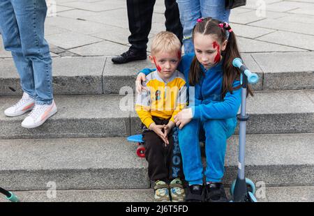 I bambini con facce dipinte prendono parte alla dimostrazione. Mogli, madri, bambini di soldati ucraini e membri del Battaglione Azov a Mariupol si sono riuniti nella piazza dell'Indipendenza per chiedere ai leader mondiali di contribuire a organizzare un corridoio umanitario per l'evacuazione di civili e militari ucraini dalla città assediata di Mariupol ai paesi neutrali. Foto Stock